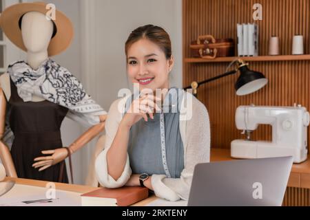 Asian tailor women holding pencil and thinking about designing new ...