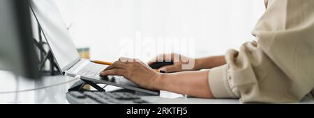 Developer programmer using mouse and typing code on laptop while programming to developing website. Stock Photo