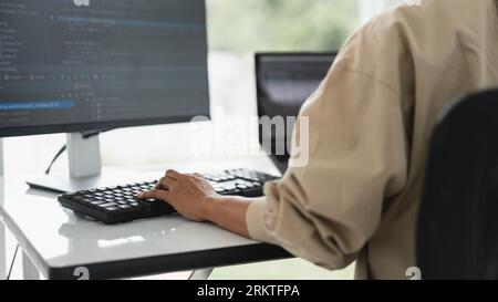 Developer programmer programming code to developing website and application in software office. Stock Photo