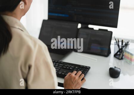 Developer programmer working about programming code to developing web and apps on multiple monitor. Stock Photo