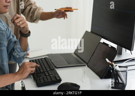 Two developer programmer discussing to checking code on monitor about programming to developing web. Stock Photo