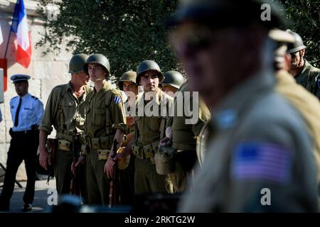 Avignon, France. 25th Aug, 2023. Soldiers dressed in World War II-era uniforms are observed in formation. Marking the 79th anniversary of Avignon's liberation in France during World War II, an exhibition showcasing a range of military and civilian vehicles unfolds in front of the town hall. Credit: SOPA Images Limited/Alamy Live News Stock Photo