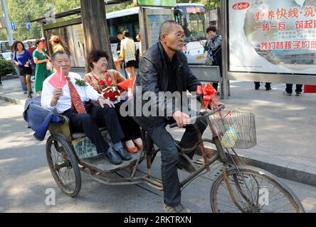 Bildnummer: 58543441  Datum: 01.10.2012  Copyright: imago/Xinhua (121002) -- NANJING, Oct. 2, 2012 (Xinhua) -- Tan Enxiang (L) and Peng Yuehua board on a tricycle and pose for wedding photos during a ceremony marking their golden wedding anniversary in Nanjing, capital of east China s Jiangsu Province, Oct. 1, 2012. The ceremony, acting as grand as the wedding ceremony held for newlyweds, was initiated by children of the old couple who didn t have a decent wedding ceremony due to the economic condition fifty years ago. (Xinhua/Sun Can) (hdt) CHINA-NANJING-GOLDEN WEDDING (CN) PUBLICATIONxNOTxIN Stock Photo