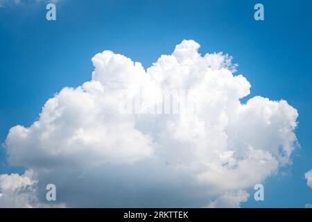 Large singleCumulonimbus clouds. cumulus cloud. Puffy or cotton like or fluffy cloud blue sky white fluffy clouds over blue sky landscape. Stock Photo