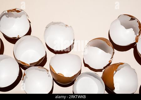 Cracked eggshell arranging on neutral background. Stock Photo