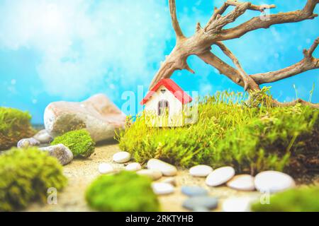 Small wooden house with moss, driftwood and stones. Natural background, copy space. Stock Photo