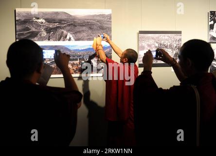 Bildnummer: 58591873  Datum: 15.10.2012  Copyright: imago/Xinhua (121015) -- BEIJING, Oct. 15, 2012 (Xinhua) -- Several men from southwest China s Tibet Autonomous Region take pictures of a photo with their cellphones at an exhibition in China s capital city Beijing, Oct. 15, 2012. A photo show of the 1st Impression Tibet Photography Competition opened in the National Center for the Performing Arts on Monday. More than 300 photos about Tibet are displayed. (Xinhua/Luo Xiaoguang) (wjq) CHINA-BEIJING-TIBET-PHOTOGRAPHY EXHIBITION (CN) PUBLICATIONxNOTxINxCHN Kultur Kunst Ausstellung xas x0x 2012 q Stock Photo