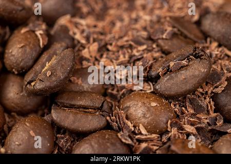 Roasted coffee beans lie together with chocolate crumbled into small pieces, fragrant coffee together with chocolate crumbs Stock Photo