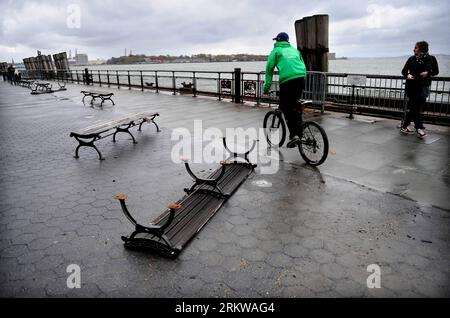 Bildnummer: 58651221  Datum: 30.10.2012  Copyright: imago/Xinhua (121030) -- NEW YORK, Oct. 30, 2012 (Xinhua) -- A person on bicycle passes by a toppled bench in Manhattan, New York, Oct. 30, 2012. Sandy, which made landfall in New Jersey early Monday evening and combined with winter storms to become a hybrid storm, has impacted 15 states. The death toll has risen to 18 and may continue to rise in the largest city of the country, New York City Mayor said Tuesday. (Xinhua/Shen Hong) US-NEW YORK-AFTER-HURRICANE SANDY-MESS PUBLICATIONxNOTxINxCHN Gesellschaft USA Katastrophe Sturm Wirbelsturm Hurr Stock Photo