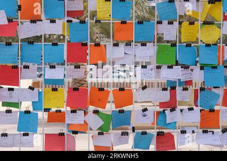 Multi-colored paper notes, stickers with names , memo, notice, requests and romantic wishes as background .  Stock Photo