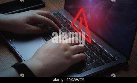 Woman use laptop with system hacked alert. Compromised information concept. Internet virus cyber security and cybercrime. Stock Photo