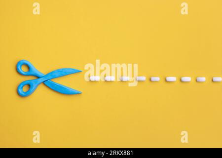 Plasticine 3d scissors with cut lines on yellow background. Concept of craft works, design or fashion, DIY tools. Stock Photo