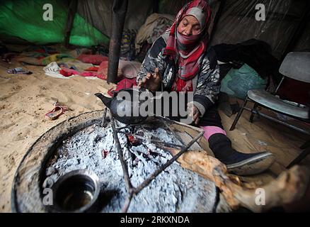 Bildnummer: 59014464  Datum: 10.01.2013  Copyright: imago/Xinhua (130110) -- GAZA, Jan. 10, 2013 (Xinhua) -- A Palestinian woman makes tea by a fire at her tent in a poor neighborhood during the heavy storm in Gaza City on Jan. 10, 2013. Since Jan. 8, it has been raining heavily in the West Bank and the Gaza Strip. (Xinhua/Yasser Qudih) (dzl) MIDEAST-GAZA-RAIN PUBLICATIONxNOTxINxCHN Gesellschaft Kochstelle Armut Tee kochen x0x xac 2013 quer      59014464 Date 10 01 2013 Copyright Imago XINHUA  Gaza Jan 10 2013 XINHUA a PALESTINIAN Woman makes Tea by a Fire AT her Tent in a Poor Neighborhood du Stock Photo