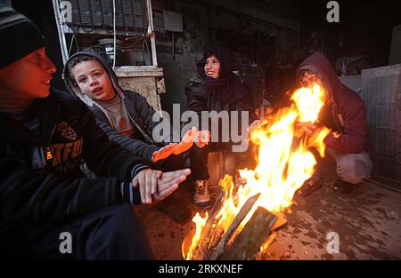 Bildnummer: 59014476  Datum: 10.01.2013  Copyright: imago/Xinhua (130110) -- GAZA, Jan. 10, 2013 (Xinhua) -- Palestinian children warm themselves by a fire at a workshop in Gaza City on Jan. 10, 2013. Since Jan. 8, it has been raining heavily in the West Bank and the Gaza Strip. (Xinhua/Yasser Qudih) (dzl) MIDEAST-GAZA-RAIN PUBLICATIONxNOTxINxCHN Gesellschaft Winter Jahreszeit Feuer Kälte Armut Kind x0x xac 2013 quer      59014476 Date 10 01 2013 Copyright Imago XINHUA  Gaza Jan 10 2013 XINHUA PALESTINIAN Children warm themselves by a Fire AT a Workshop in Gaza City ON Jan 10 2013 Since Jan 8 Stock Photo