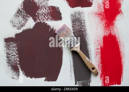 Concept Of A Paintbrush On A Piece Of Paper With Brush Strokes With Red And Brown Paint. Stock Photo