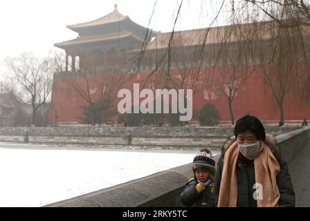 Bildnummer: 59152313  Datum: 30.01.2013  Copyright: imago/Xinhua (130130) -- BEIJING, Jan. 30, 2013 (Xinhua) -- Pedestrians with masks walk past the moat of the Forbidden City in Beijing, capital of China, Jan. 30, 2013. The meteorological observatory in Beijing issued an orange alert and a yellow alert against heavy fog and haze respectively on 6:00 am Wednesday. Heavy fog has been lingering in central and eastern China since Tuesday afternoon, disturbing the traffic. (Xinhua/Li Fangyu) (xzj) CHINA-BEIJING-FOG (CN) PUBLICATIONxNOTxINxCHN Gesellschaft Wetter Nebel Luftverschmutzung Umweltversc Stock Photo