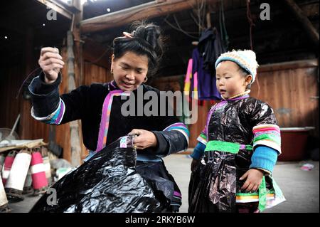 Bildnummer: 59190678  Datum: 07.02.2013  Copyright: imago/Xinhua (130208) -- KAILI, Feb. 7, 2013 (Xinhua) -- A woman of Dong ethnic group sows buttons for new clothing made of self-produced cloth in Xiaohuang Village of Kaili City, southwest China s Guizhou Province, Feb. 7, 2013. The handmade cloth was used by local to make traditional costumes of Dong ethnic group to greet the upcoming Spring Festival, or the Chinese Lunar New Year, which falls on Feb. 10 this year. (Xinhua/Lai Xinlin) (ry) CHINA-GUIZHOU-DONG ETHNIC GROUP-CLOTH MAKING (CN) PUBLICATIONxNOTxINxCHN Gesellschaft Kultur Frühlings Stock Photo