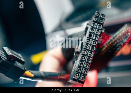 Cable connector (24 pin) from power supply unit of desktop PC close-up with blurred background. Computer wires hardware components Stock Photo