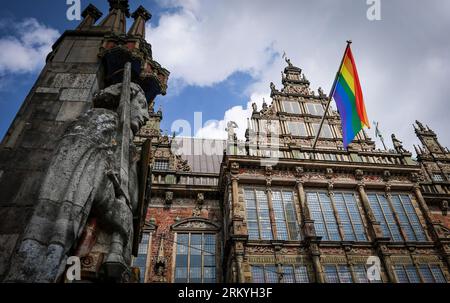 Bremen, Germany. 26th Aug, 2023. A rainbow flag hangs on the facade of City Hall behind Rolandi during Christopher Street Day (CSD). The police expected 10,000 to 12,000 people for the demonstration procession through the Hanseatic city. Credit: Focke Strangmann/dpa/Alamy Live News Stock Photo