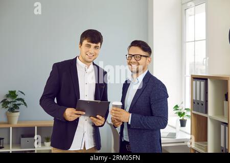 Portrait of two happy business people, colleagues and friends at work in the office Stock Photo