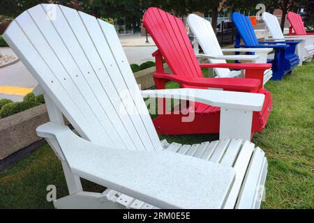 Diminishing perspective view of the Adirondack chairs on a city park Stock Photo