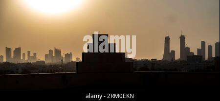 Bahrain skyline silhouette against the setting sun Stock Photo