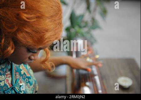 Bildnummer: 59440561  Datum: 25.03.2013  Copyright: imago/Xinhua Aida Yang plays Guqin, a seven-stringed plucked instrument, in her studio in Beijing, capital of China, March 7, 2013. I feel that he is a good man, and I want to be with him. Recalling the first time Aida saw her husband two years ago in her hometown Freetown, the 26-year-old Barbie-like lady lost in sweet memory, Language or distance is not a problem. This love at first sight unveiled when the Sierra Leone girl met with Yang Yan, a 58-year-old Chinese painter two years ago when Yang Yan traveled to Aida s hometown Freetown, Sie Stock Photo