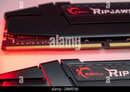 Kyiv, Ukraine - January 05, 2022: G.Skill Ripjaws V series DDR4 DRAM memory modules in red light. Computer RAM chip close-up on white. Desktop PC memo Stock Photo