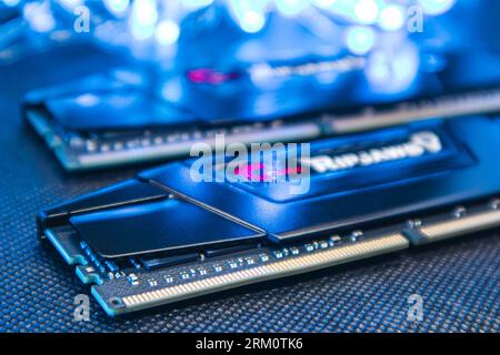 Kyiv, Ukraine - January 05, 2022: G.Skill Ripjaws V series memory module DDR4 DRAM with electrical contacts in blue light. Computer RAM chipset close- Stock Photo