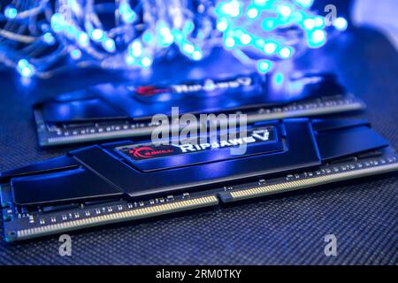 Kyiv, Ukraine - January 05, 2022: G.Skill Ripjaws V series memory module DDR4 DRAM with electrical contacts in blue light. Computer RAM chipset close- Stock Photo