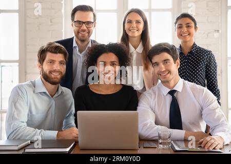 Portrait of smiling diverse employees working on laptop Stock Photo