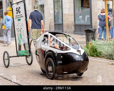 'eCvelo' human-powered tricycle / velomobile capsule towing advert for 'Retreeb' payment system in city center - Tours, Indre-et-Loire (37), France. Stock Photo