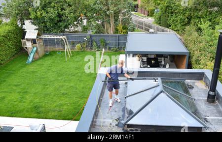 Man is cleaning the roof top windows on a nice day. Stock Photo