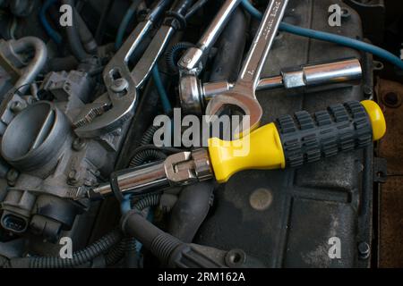 work in the workshop on parts of a car engine, spark plug of the internal combustion engine, the heart of the internal combustion engine. Stock Photo
