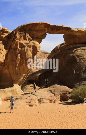 Tourists at the Burdah rock bridge, Wadi Rum, Unesco World Heritage Site, Jordan, Middle East Stock Photo