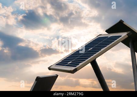 View of solar panel against clouds in the sunset sky - close up Stock Photo