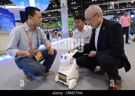 Bildnummer: 59723037  Datum: 29.05.2013  Copyright: imago/Xinhua (130529) -- BEIJING, May 29, 2013 (Xinhua) -- An exhibitor (L) introduces to the visitors the functions of the family robot during the China Beijing International Fair for Trade in Services (Beijing Fair) in Beijing, capital of China, May 29, 2013. The robot, made by the Chinese Academy of Sciences and Tsinghua University, attracted many visitors during the fair for its special functions, such as monitoring, communicating and taking care of elder people. (Xinhua/Zheng Yong) (zwx) CHINA-BEIJING-BEIJING FAIR-FAMILY ROBOT(CN) PUBLIC Stock Photo