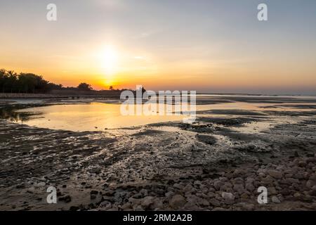 Sunset, Bahrain Al-Seef, Karbabad beach. Oil spilled reaches the beach leaving oil globs Stock Photo