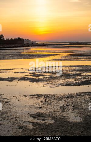 Sunset, Bahrain Al-Seef, Karbabad beach. Oil spilled reaches the beach leaving oil globs Stock Photo