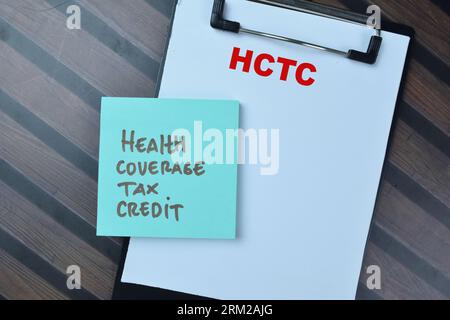 Concept of HCTC - Health Coverage Tax Credit write on sticky notes isolated on Wooden Table. Stock Photo