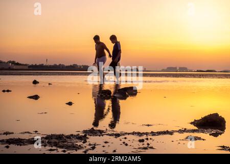 Two boys walking with filled water filled in plastic containers, Stock Photo