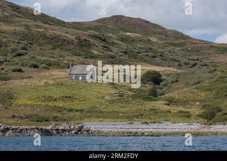 A small cottage on a Scottish island seen from the sea Stock Photo