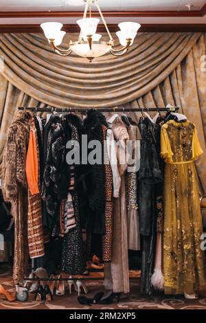 Women's evening long dresses hanging on hangers on the fashion backstage in the vintage interior Stock Photo