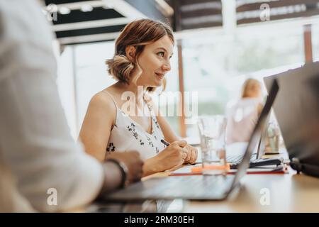 In a vibrant office, a diverse group works together discussing ideas, analyzing data, optimizing efficiency, and achieving business success. Stock Photo