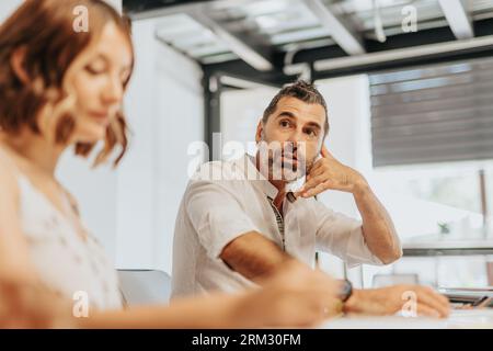 A diverse team of professionals discussing business analytic, project development, and profit growth in an office workspace. Stock Photo