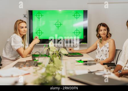 A diverse business team analyzing statistics and discussing project development in an office. Multicultural group focused on profitable growth. Stock Photo