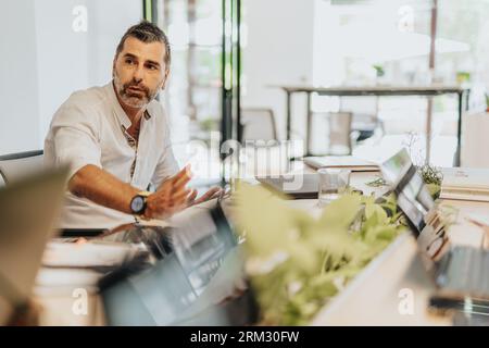 A diverse group of business professionals collaborating in an office, analyzing statistics and planning for profit growth. Stock Photo