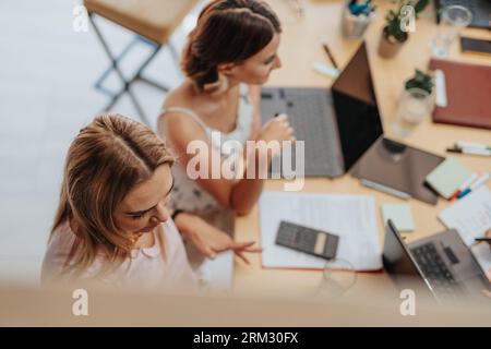 Inter-generational female business employees working together at modern office room. Top view photo. Stock Photo