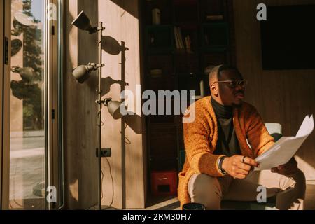 Tired black male person was distracted by something while reading a document Stock Photo