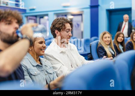Three young university students sitting together in the conference room Stock Photo